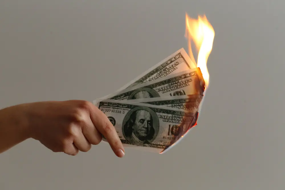 How Dirty AC Filters Affect Your Wallet - Picture of a hand holding money that is on fire. Meant to depict burning through money.