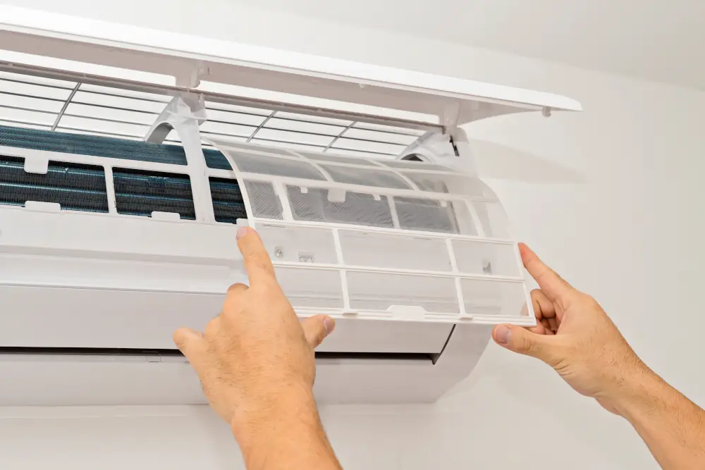 The Link Between Allergies and Poor Indoor Air Quality - Person changing air filter on a ductless ac unit
